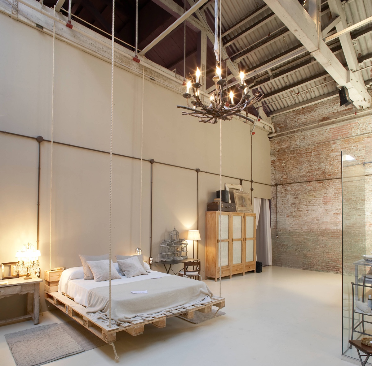 barn-style-with-chandelier-exposed-brick-bedroom 