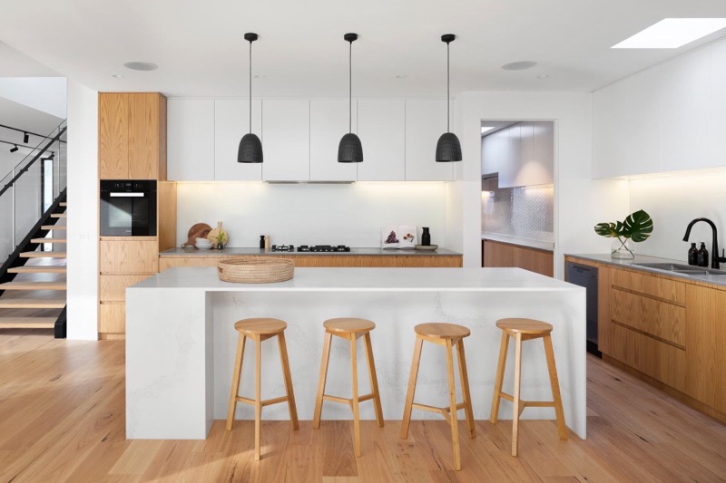 A large kitchen with statement pendant lights hanging over a kitchen island