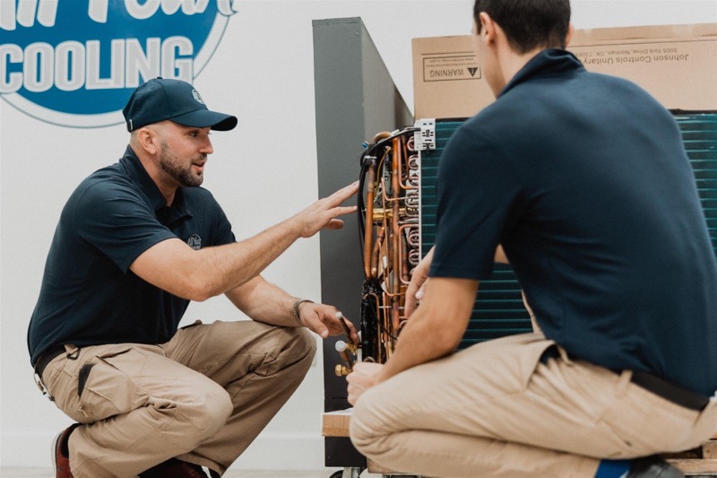 A picture of an All Year Cooling And Heating employee going over an AC before doing a test run